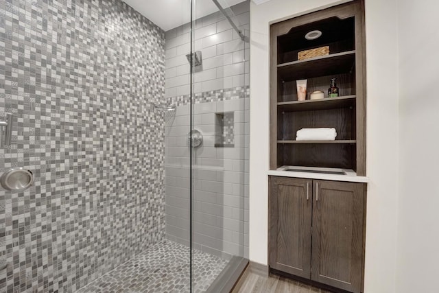 bathroom with a stall shower and wood finished floors