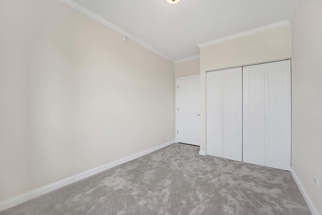 unfurnished bedroom with a closet, baseboards, crown molding, and carpet flooring