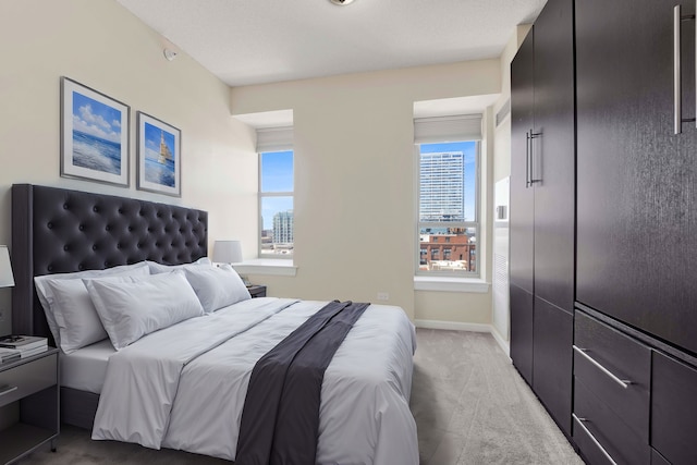 bedroom featuring light carpet and baseboards