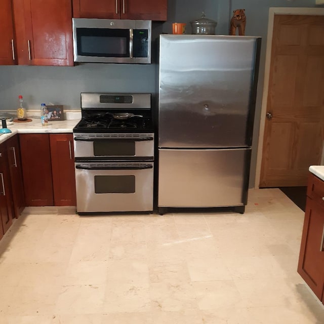 kitchen featuring light floors, appliances with stainless steel finishes, and light countertops