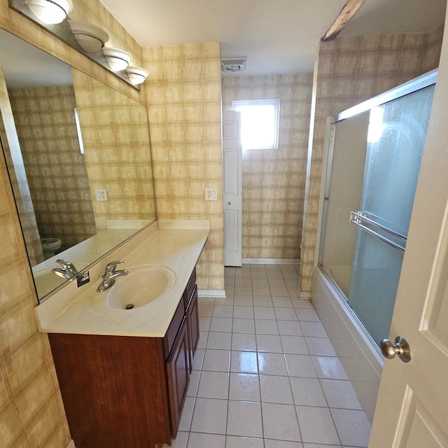 bathroom with wallpapered walls, visible vents, tile patterned flooring, combined bath / shower with glass door, and vanity