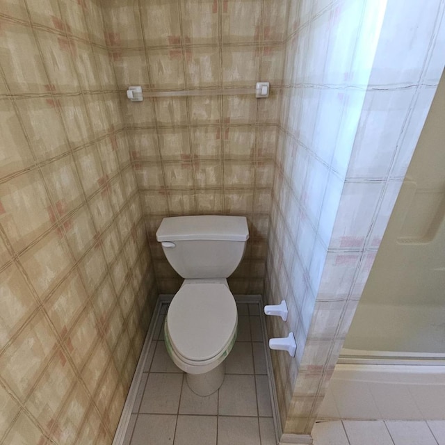 full bathroom with toilet, tile patterned flooring, an enclosed shower, and tile walls