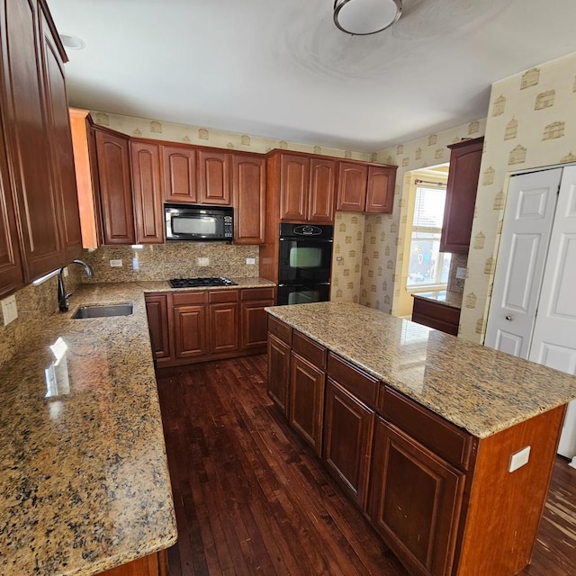 kitchen featuring a kitchen island, a sink, black appliances, and dark wood-style floors