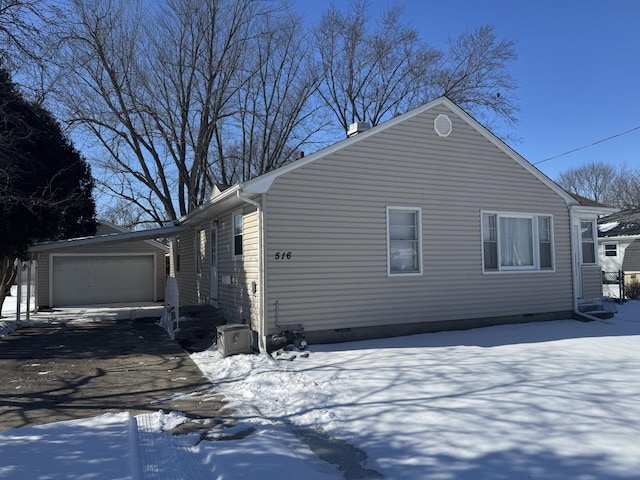 view of snow covered exterior featuring crawl space and a garage