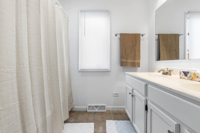 full bath featuring tile patterned flooring, a sink, visible vents, baseboards, and double vanity