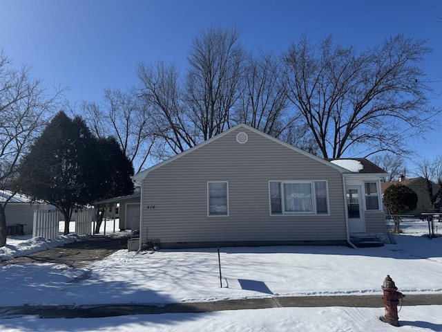 view of snowy exterior with entry steps and a garage