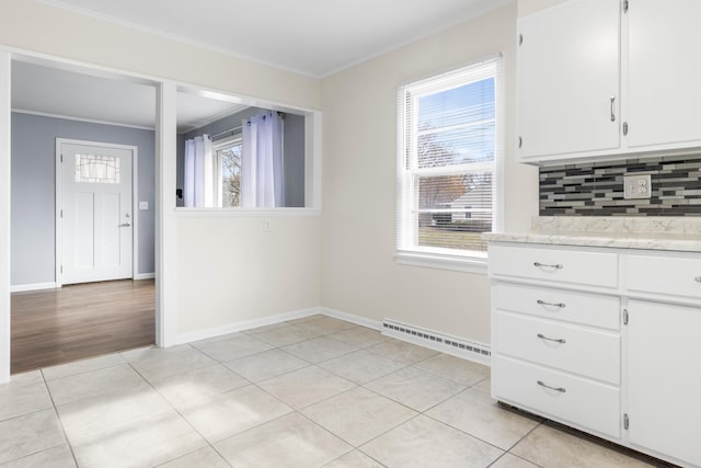 unfurnished dining area featuring light tile patterned floors, baseboards, visible vents, and crown molding