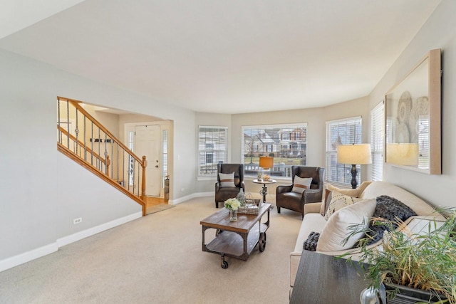 living area featuring light carpet, stairway, and baseboards