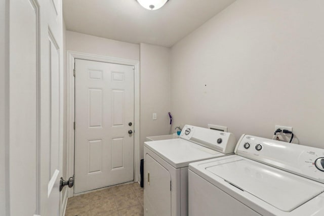 laundry area with light tile patterned floors, laundry area, independent washer and dryer, and a sink