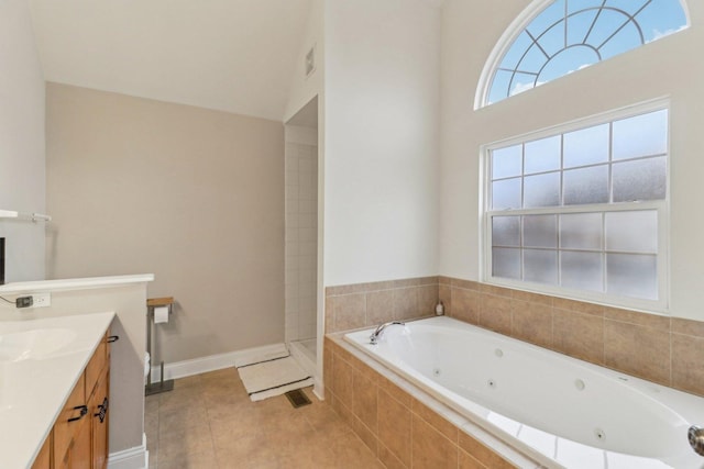 bathroom featuring tile patterned flooring, visible vents, vanity, baseboards, and a jetted tub