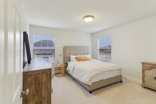 bedroom featuring light carpet and baseboards