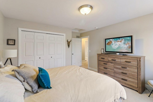 bedroom featuring a closet, light colored carpet, visible vents, and baseboards