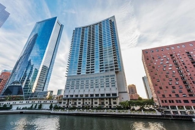 view of building exterior featuring a water view and a view of city