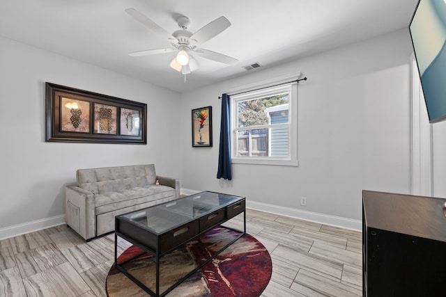 living room featuring visible vents, ceiling fan, and baseboards