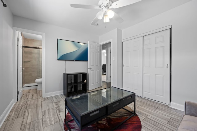 living room with a ceiling fan, wood tiled floor, and baseboards