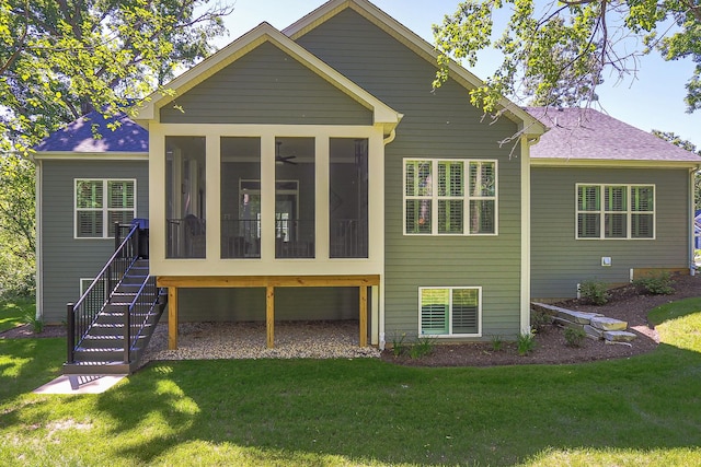 back of house with a sunroom, roof with shingles, a lawn, and stairway