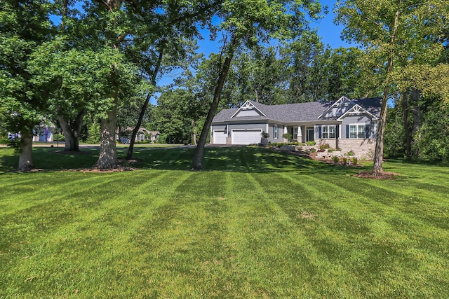 view of front of home featuring a front lawn, driveway, and an attached garage