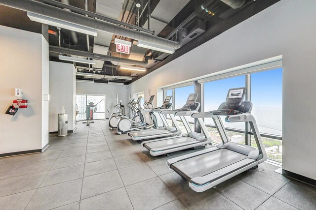 gym featuring a towering ceiling and baseboards