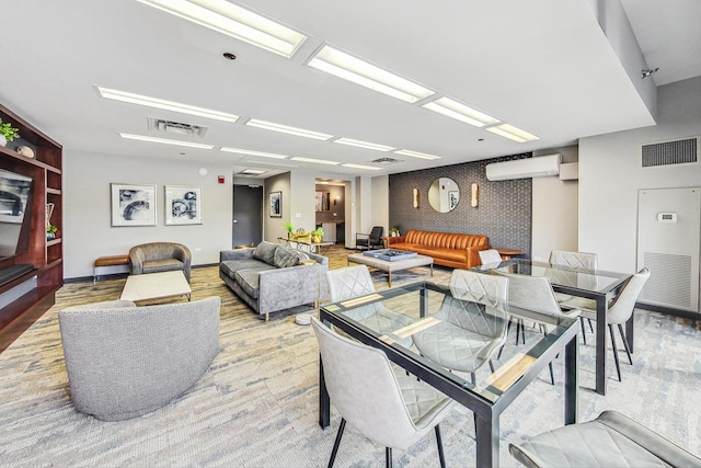 dining area with an accent wall, a wall mounted AC, visible vents, and baseboards