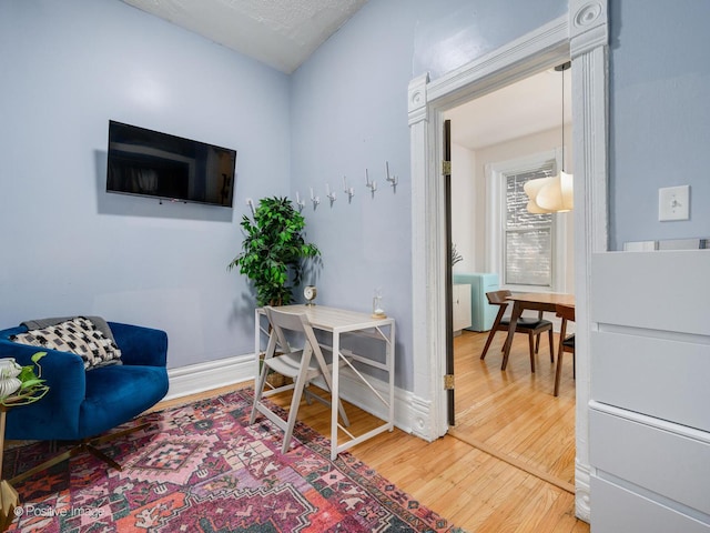 sitting room featuring baseboards and wood finished floors