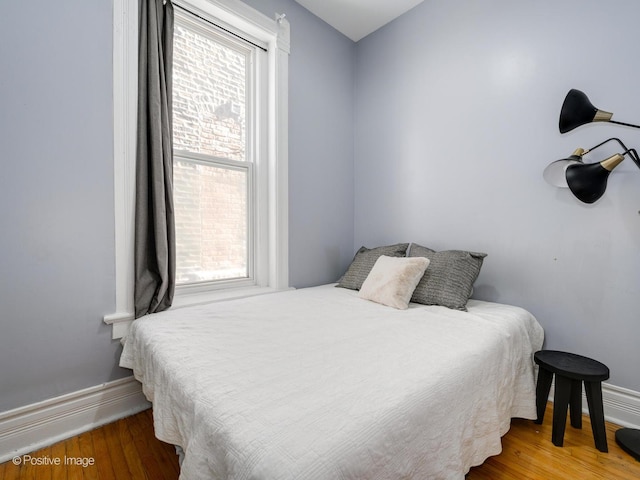 bedroom featuring wood finished floors and baseboards