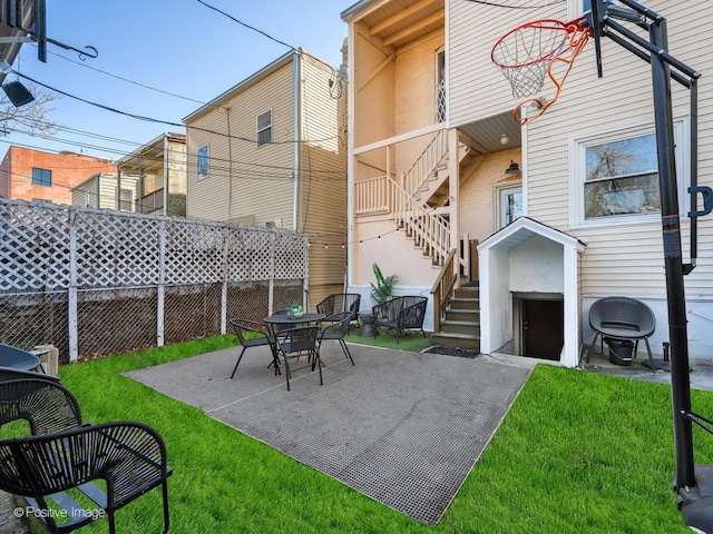 view of patio featuring fence and stairs