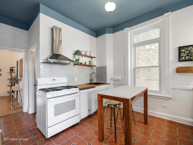 kitchen featuring white appliances, a sink, wall chimney range hood, open shelves, and tasteful backsplash