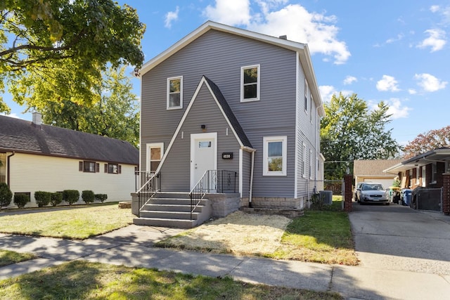 view of front facade featuring an outbuilding, central AC unit, and a front yard