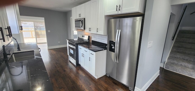 kitchen with dark wood finished floors, white cabinetry, backsplash, and stainless steel appliances