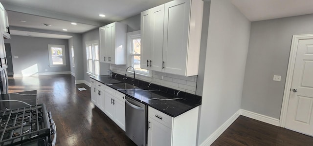 kitchen featuring dark wood finished floors, a sink, decorative backsplash, dishwasher, and dark countertops