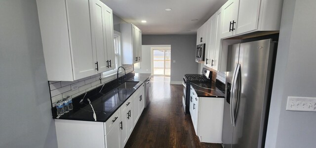 kitchen featuring backsplash, dark wood-style floors, appliances with stainless steel finishes, and a sink