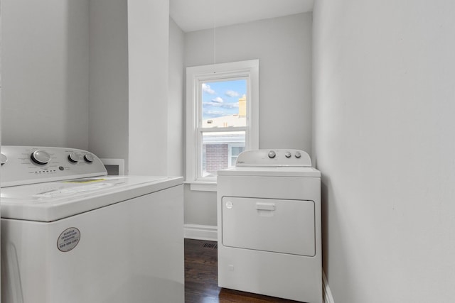 laundry room featuring baseboards, separate washer and dryer, dark wood-style flooring, and laundry area