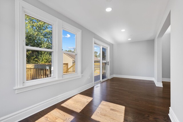 unfurnished room with recessed lighting, dark wood-style floors, and baseboards