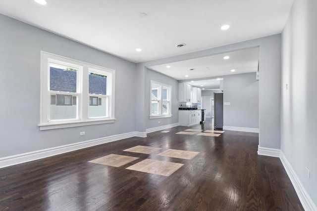 unfurnished living room featuring visible vents, recessed lighting, dark wood-style floors, and baseboards