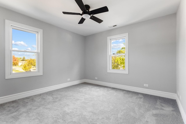 unfurnished room with visible vents, a ceiling fan, baseboards, and carpet floors