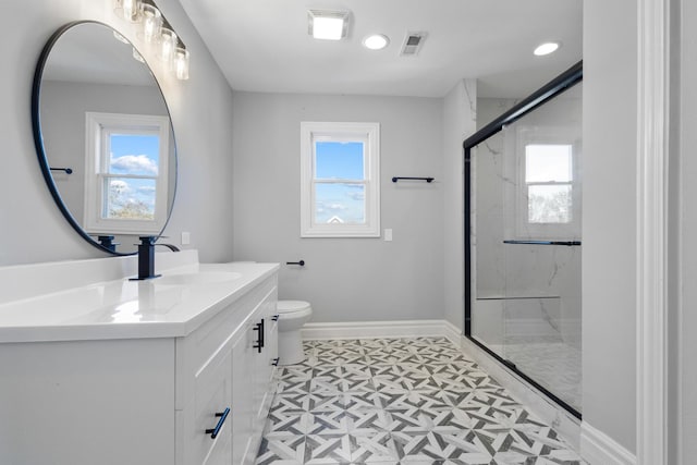 bathroom featuring vanity, baseboards, visible vents, a marble finish shower, and toilet