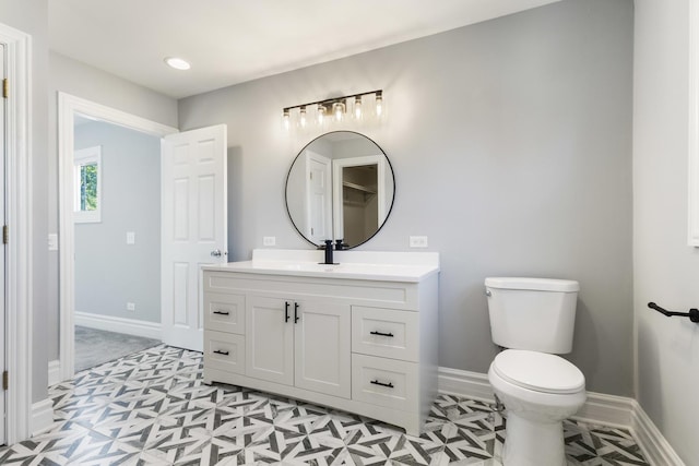 bathroom with vanity, toilet, and baseboards