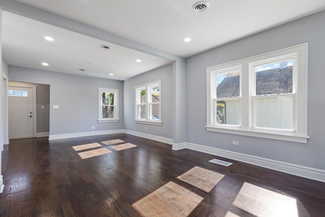 empty room with visible vents, recessed lighting, baseboards, and wood finished floors