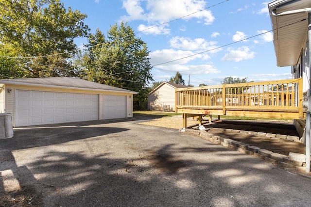 view of yard featuring an outbuilding, a wooden deck, and a garage