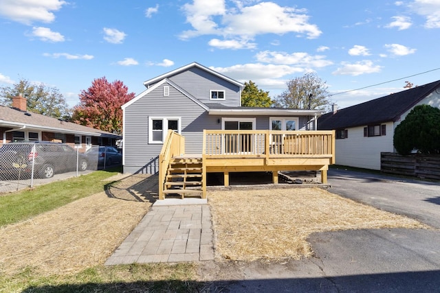 rear view of property with a wooden deck and fence