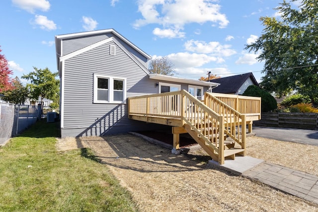 back of property with fence, a yard, stairs, a deck, and central air condition unit