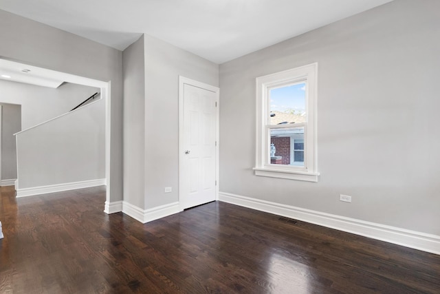 spare room with visible vents, baseboards, and wood finished floors