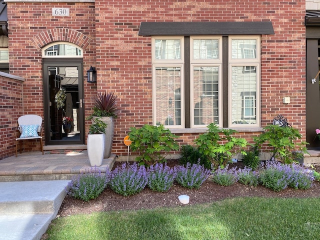 entrance to property featuring brick siding