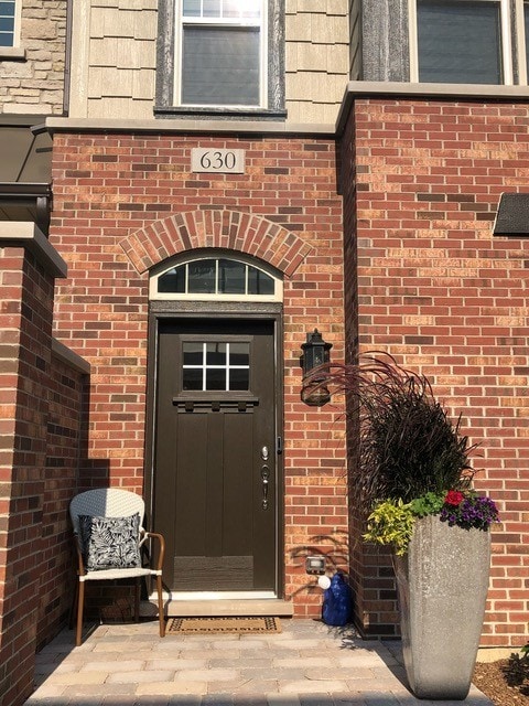 view of exterior entry featuring brick siding