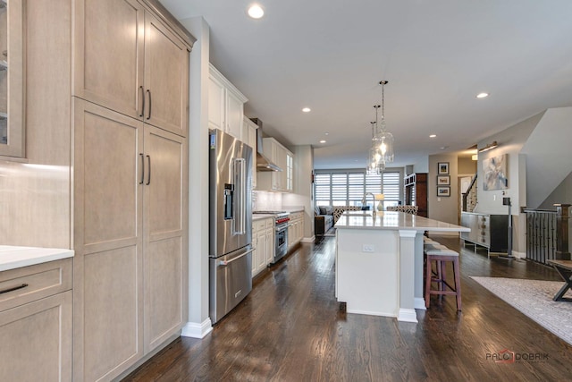 kitchen with premium appliances, a breakfast bar, open floor plan, and dark wood finished floors