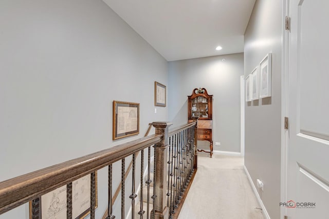 hall featuring light carpet, an upstairs landing, recessed lighting, and baseboards