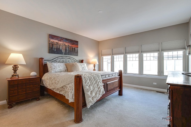 bedroom with visible vents, light colored carpet, and baseboards