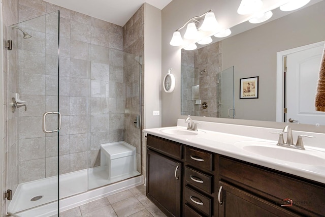 bathroom with a sink, a stall shower, double vanity, and tile patterned flooring