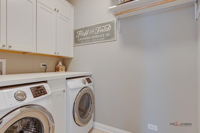 laundry area featuring baseboards, cabinet space, and washing machine and clothes dryer