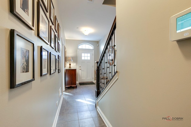 doorway to outside with tile patterned flooring, stairway, and baseboards